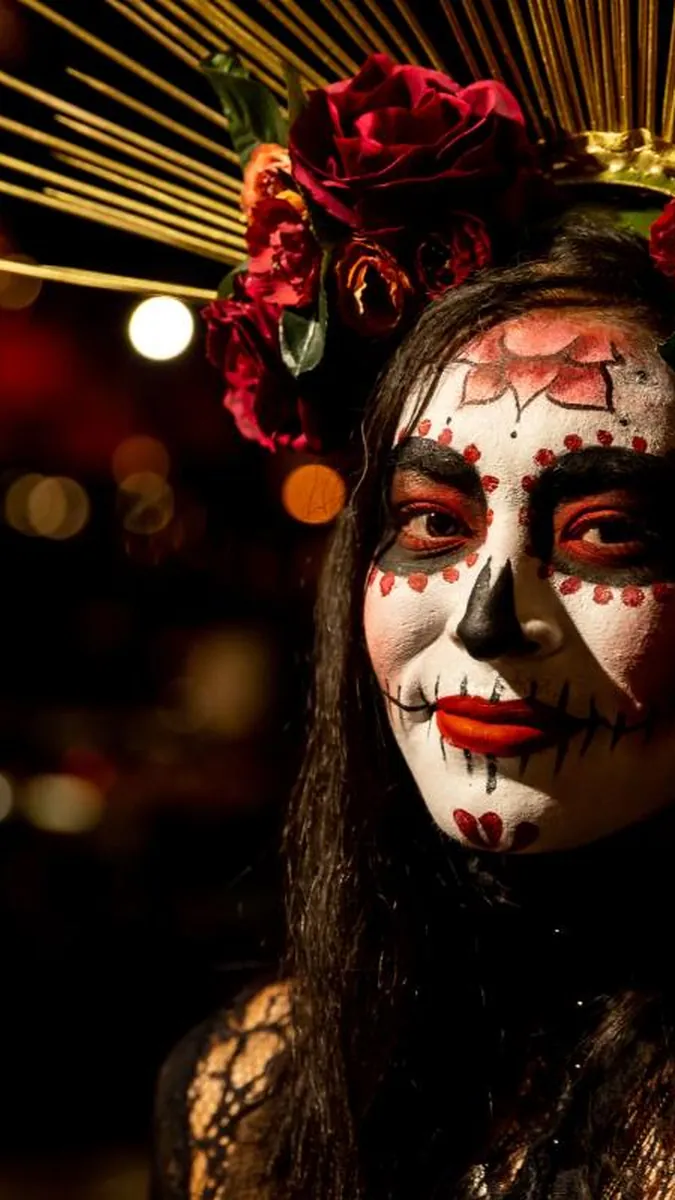 Mujer maquillada de Catrina con corona de flores, imagen de Día de Muertos de Visit Los Cabos