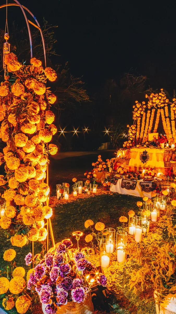 Altar de Día de Muertos cubierto de cempasúchil e iluminado con velas en Flora Farms