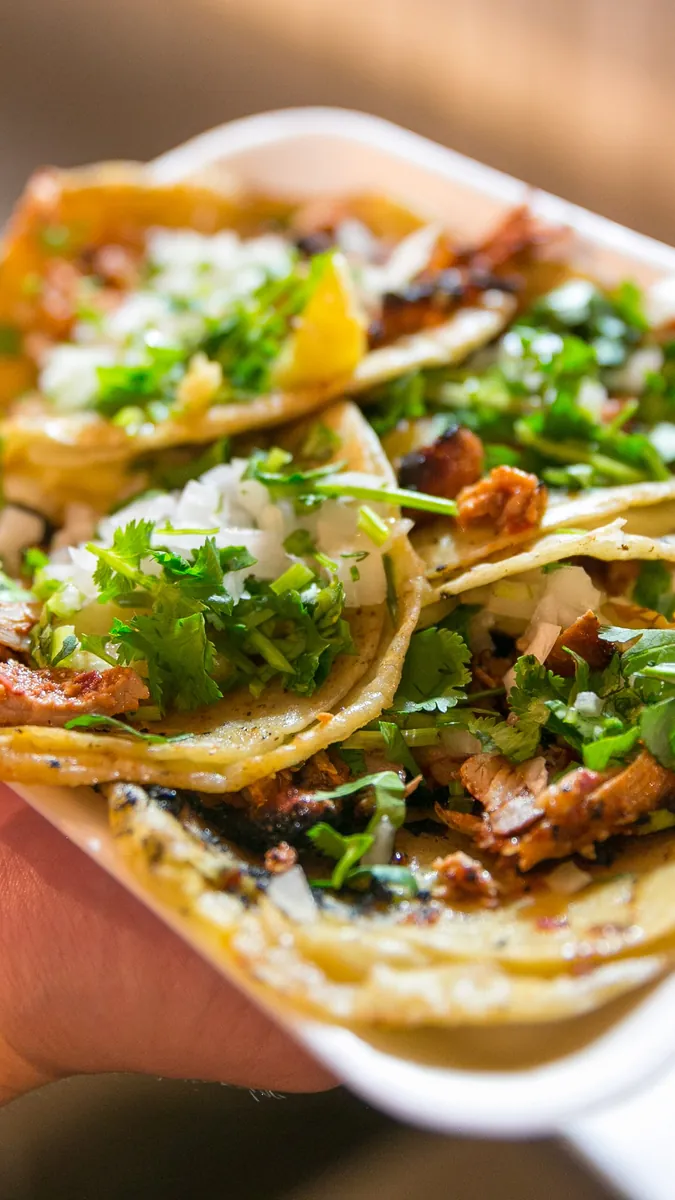 Charola de tacos al pastor con cilantro, cebolla y piña