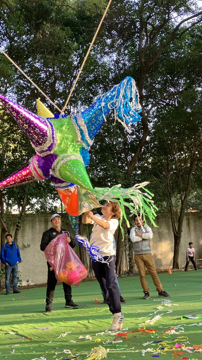 Children breaking a star piñata at a traditional Mexican posada