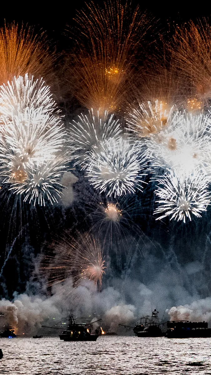 Fuegos artificiales dorados sobre el mar de noche en la costa del Pacífico mexicano