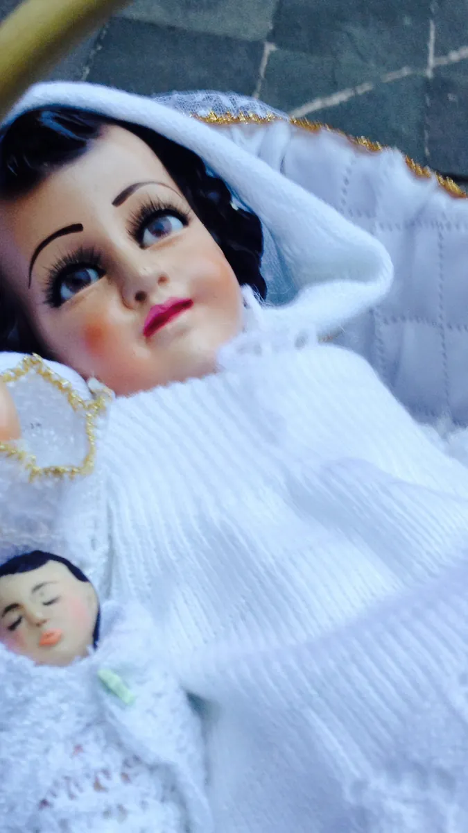 A dressed Niño Dios figure in white for Candlemas