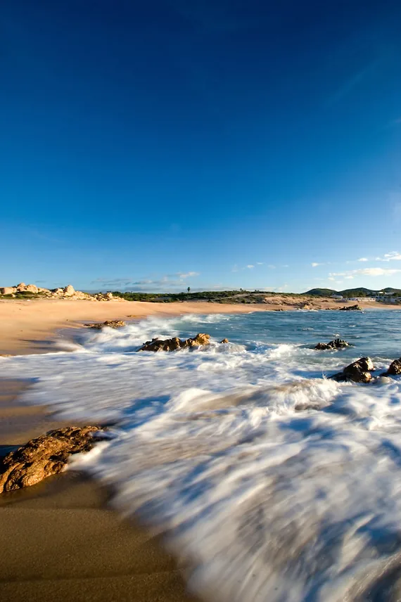 Waves running over the rocks and sand at Las Viudas Beach