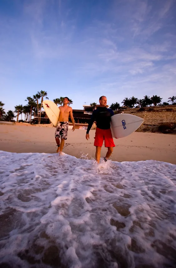 Surfistas caminando por la orilla de Playa Acapulquito, cerca de San José del Cabo